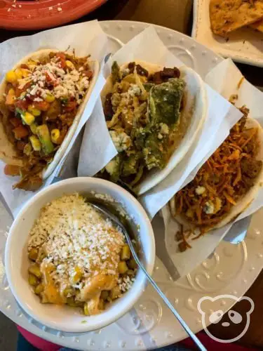 Plate of 3 tacos and side of corn. 
