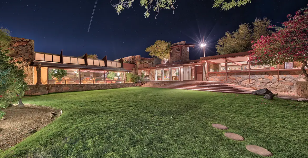 House at night with grass in the foreground.