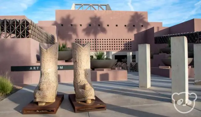 Entrance of the ASU Art Museum with cowboy boot sculptures and large white columns next to it. 
