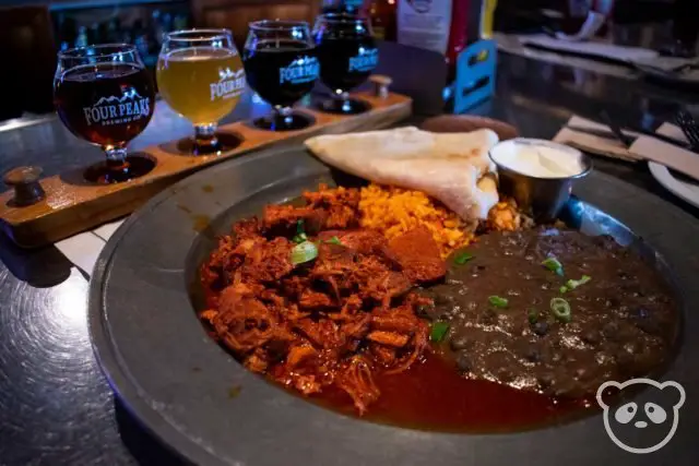 Beer flight of 4 beers with carne adovada plate in the foreground.