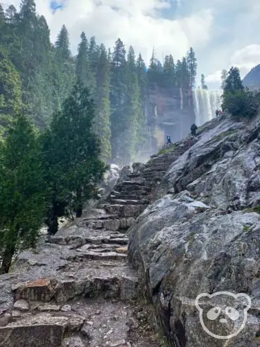 rock stairway hiking trail with waterfall in the background partially visible.