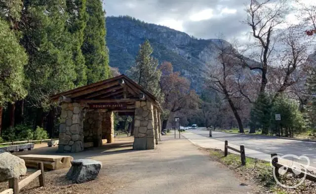 shuttle stop next to road with mountains in the background