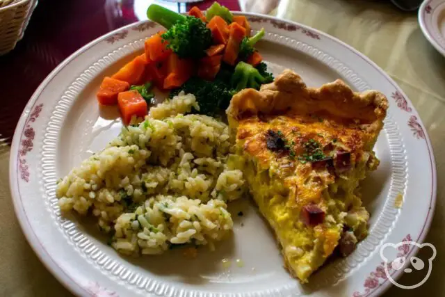 Plate of quiche with a side of steamed vegetables and rice.