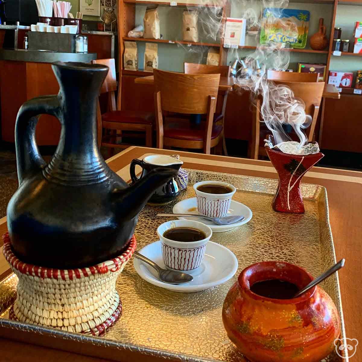 Ethiopian coffee service including coffee pot, coffee cups, sugar bowl, and incense. 