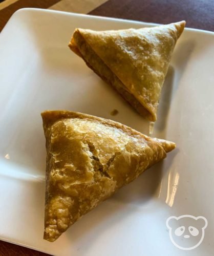 Fried sambusas on a white plate.