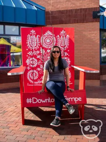 Constance sitting in a giant red chair.