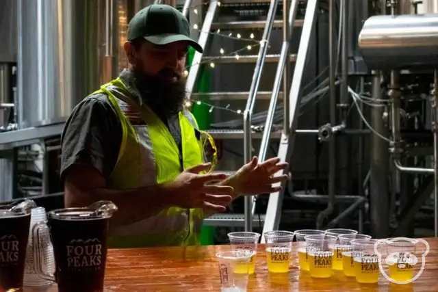 Male tour guide with small samples of beer.