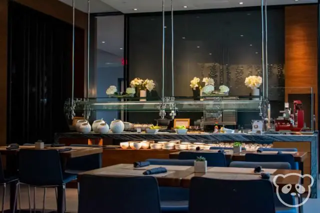 Dining room with tables in the foreground and buffet bar area in the back.