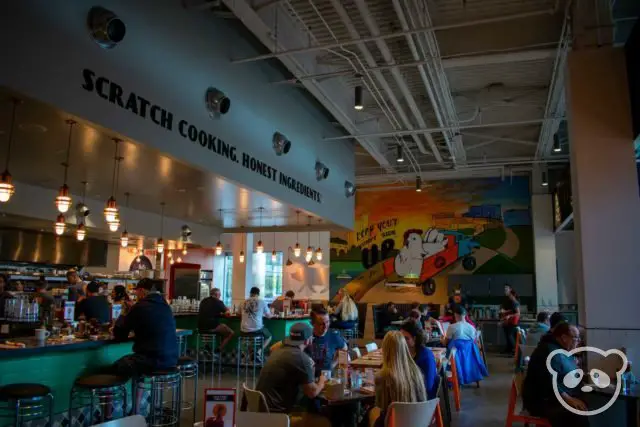 Interior of Matt's Big Breakfast, with mural at the back, bar counter seating to the left and tables.
