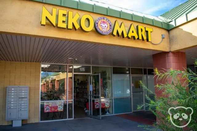 Neko Mart storefront with a plant's leaves in front.