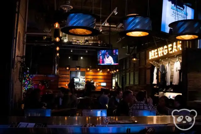 Interior of Pedalhaus breweryy with TVs and dining tables.