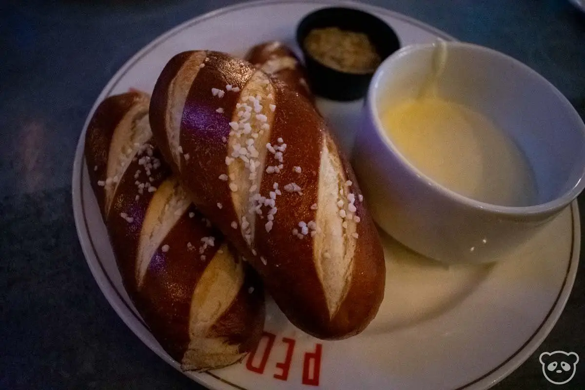 Pretzel rolls with a side of beer cheese and mustard dip.
