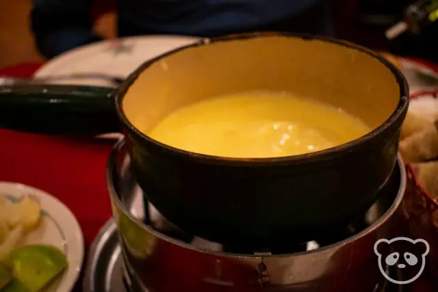 Pot of melted cheese fondue. 