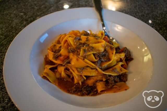 Plate with fresh pasta and veal and a fork.