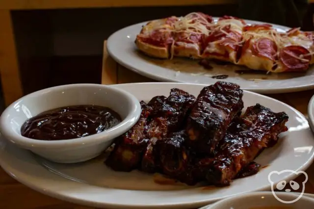 Ribs with barbecue sauce and garlic bread pepperoni pizza.