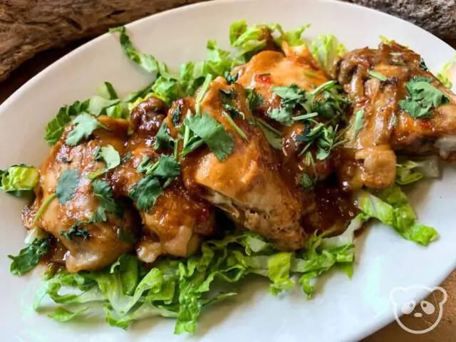 Plate of chicken thighs with a Thai style peanut sauce.